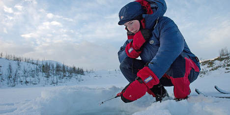 Girl wearing insulating primaloft jacket ice fishing with mormyshka ----Jente med isolerende jakke i primaloft fisker p� isen med mormyshka