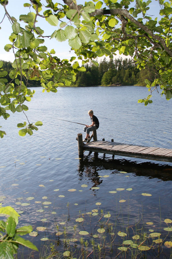 En gutt som sitter og fisker En gutt som sitter og fisker