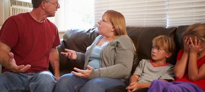 Family Sitting On Sofa With Parents Arguing