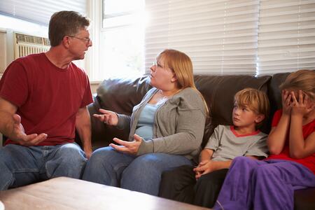 Family Sitting On Sofa With Parents Arguing