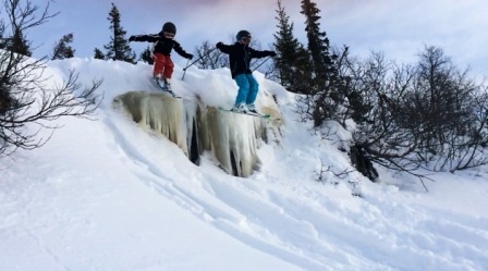 Unger hopper på ski over issvull