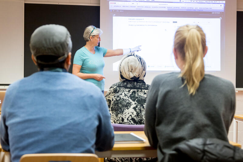 Lærer med 3 elever nærbilde