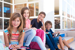 46787275 - group of school kids sitting on stairs