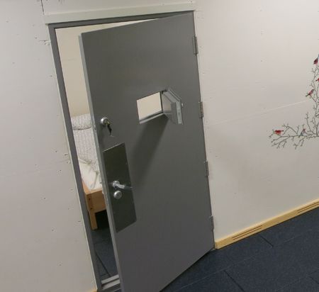 Halvåpen celledør sett fra korridor. Foto.