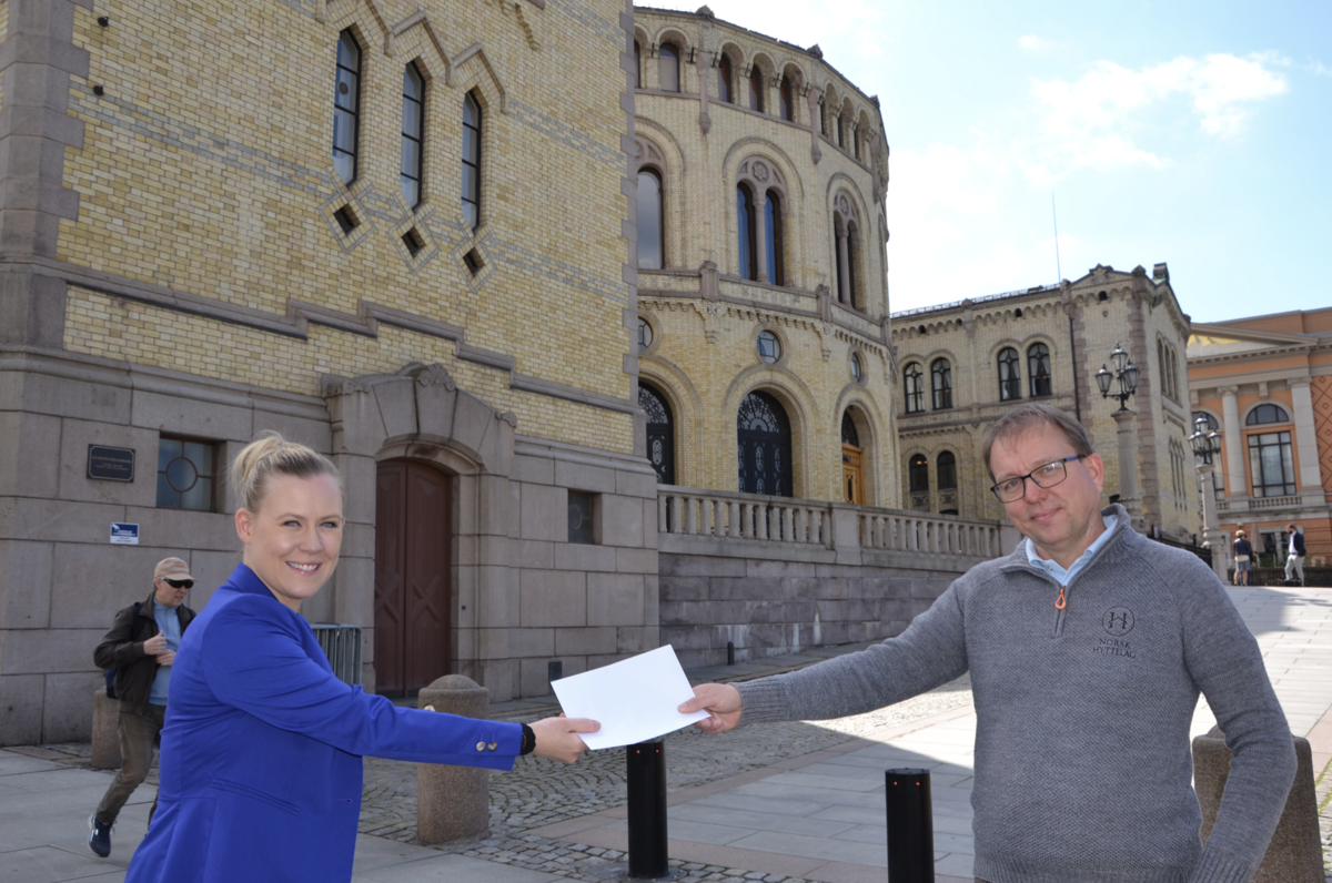 Lene Vågslid tar imot forslaget fra Audun Bringsvor foran Stortinget. Foto: Sigbjørn Larsen