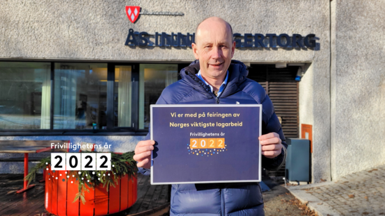 Foto av ordfører Ola Nordal med plakat for Frivillighetens år 2022