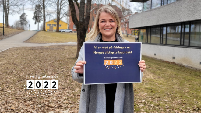 Enhetsleder Ellen Sibe Kråkenes holder opp en plakat med Frivillighetens år