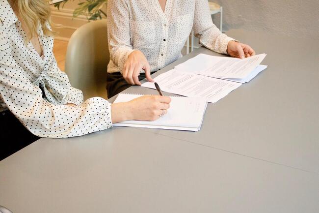 To personer signerer et dokument