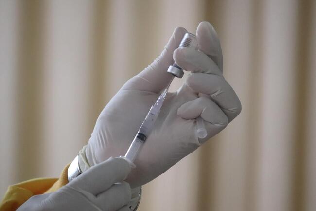 Hånd som trekker opp en vaksinesprøyte