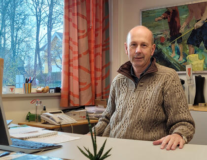 Portrettfoto av ordfører Ola Nordal bak pulten på kontoret sitt