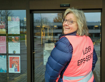 Portrettfoto av folkehelserådgiver Bente Sperlin i en rosa vest utenfor Ås kulturhus