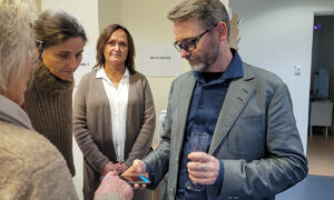 Robert Nörler Wright står til høyre i bildet, han holder fram en telefon med en app, rundt han står flere og følger med på skjermen