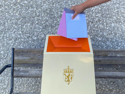 To stemmesedler holdes over en urne