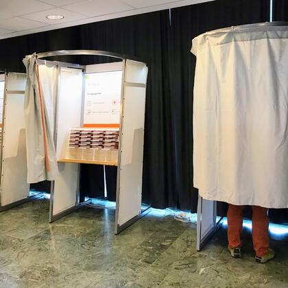 Bilde av noen som står i valglokalet, klar for å avgi sin stemme.