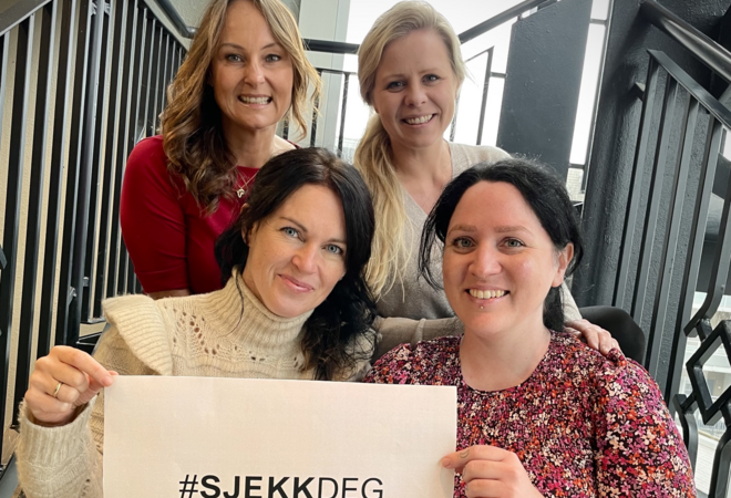 Fire jordmødre fra Ås helsestasjon holder en plakat med teksten #sjekkdeg