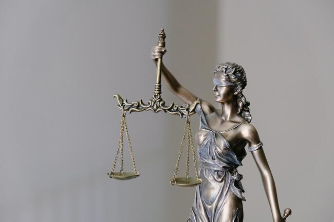 En figur som viser Justicia med vektskål og bind for øynene