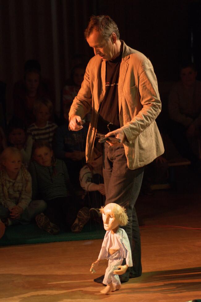 Mann som manipulerer en dukke på en scene