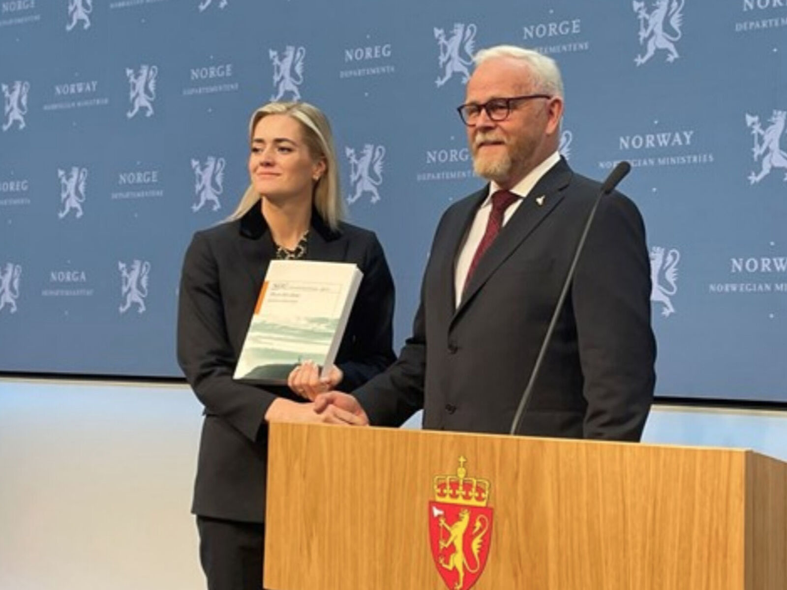 Justis- og beredskapsminister Emilie Enger Mehl (t.v.) mottar Totalberedskapskommisjonens rapport av kommisjonsleder Harald Sunde. Foto: Justis- og beredskapsdepartementet.