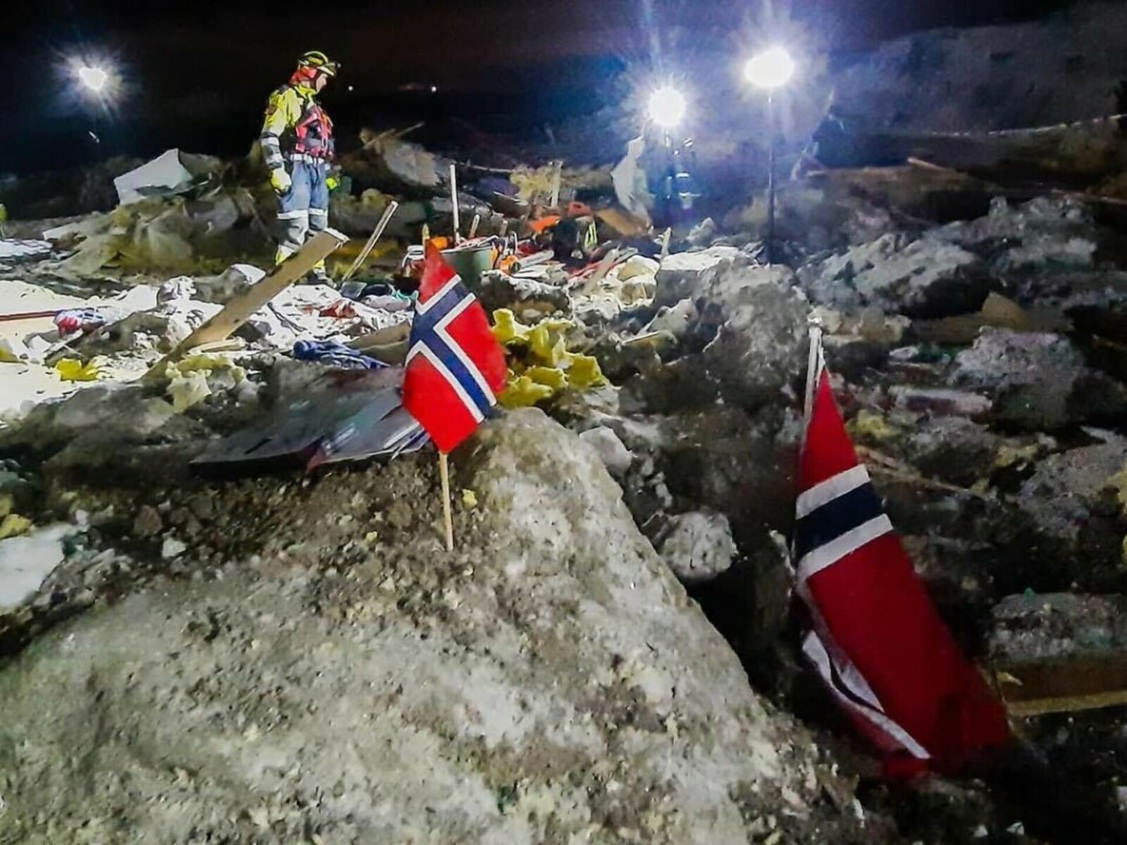 Brann- og redningsmannskaper i Nedre Romerike brann- og redningsvesen i arbeid etter leirskredet i Gjerdrum natt til 30. desember 2020. Kvikkleireskredet tok med seg flere bolighus i boligområdet Nystulia i Ask samt bygninger på gårdstunet Holmen og drøyt 100 meter av veien Fjellinna. Foto: Nedre Romerike brann- og redningsvesen.