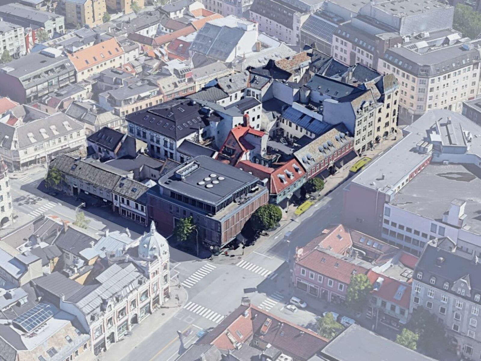 Krambukvartalet i Trondheim er valgt ut som case for storbrann. Kvartalet er en kompleks blanding av eldre burgårder, tett trehusbebyggelse og nyere bygninger. Foto: Google Earth