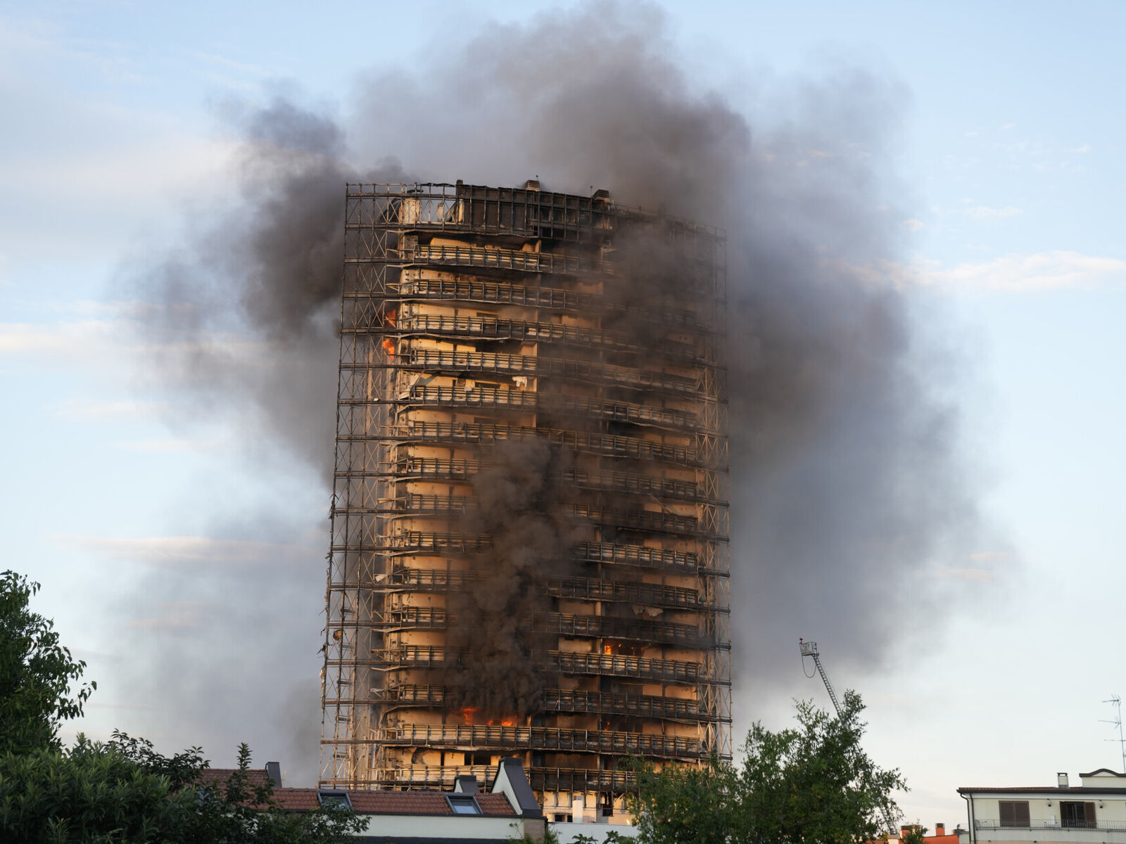 Brannmenn kjempet mot den voldsomme brannen søndag, som spredte seg raskt gjennom en nylig ombygd 60 meter høy, 16 etasjer stor boligblokk i Milano. Foto: Luca Bruno