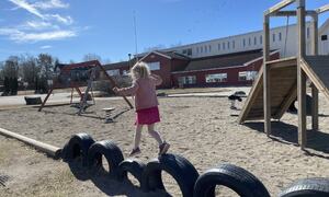 En jente leker på lekeplassen ved skolen