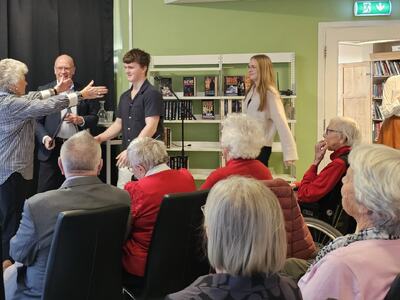 Bokprosjekt skaper gode møter mellom unge og eldre. Fra bokutdelingen. Til venstre ordfører Syver Leivestad, og til høyre Tiril Todal fra Frivilligsentralen. Foto: Kristine Mesgrahl, Fylkesbiblioteket