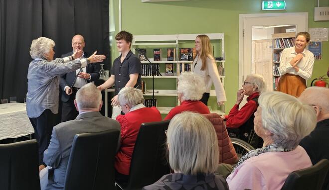 Bokprosjekt skaper gode møter mellom unge og eldre. Fra bokutdelingen. Til venstre ordfører Syver Leivestad, og til høyre Tiril Todal fra Frivilligsentralen. Foto: Kristine Mesgrahl, Fylkesbiblioteket