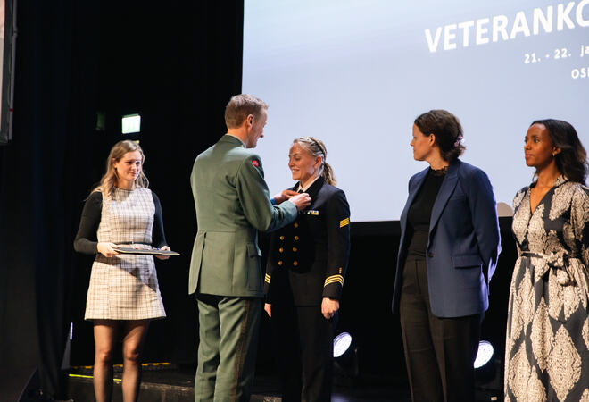 En medalje blir delt ut på scenen