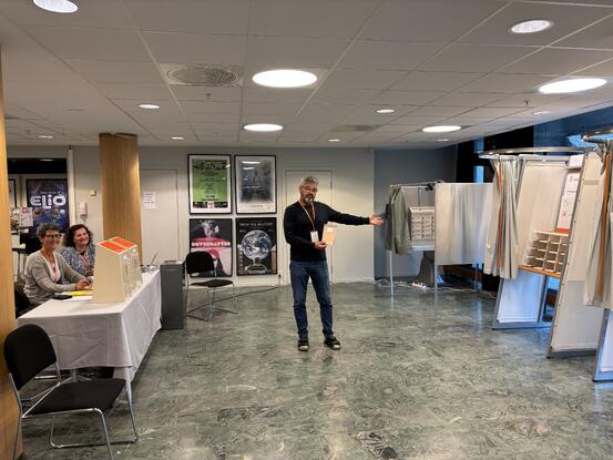 Tre valgmedarbeidere står klare i valglokalet på Ås kulturhus
