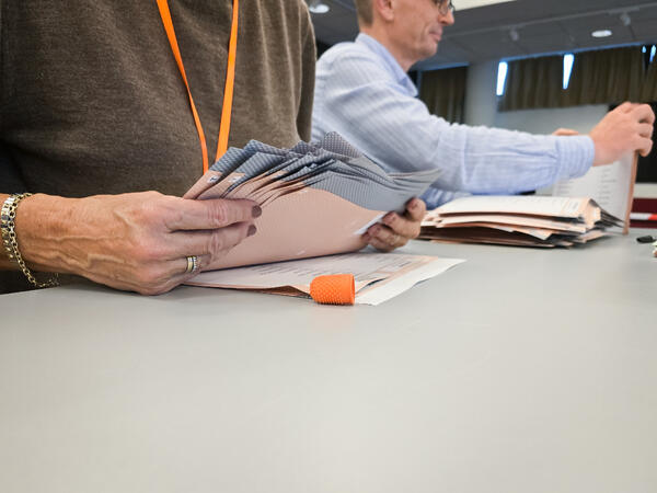 En dame og en mann teller stemmer