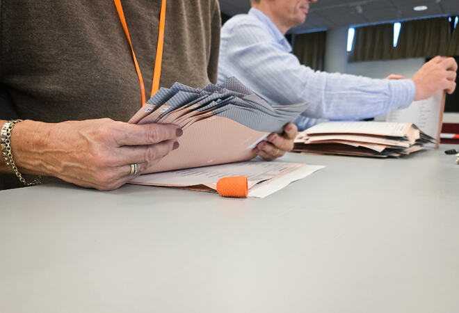 En dame og en mann teller stemmer