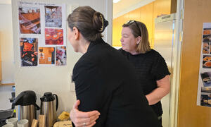 Yvonne viser Heidi bilder på veggen, bildene viser aktiviteter på Granheimtunet