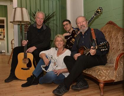 Foto av en gruppe med gitarer. 3 menn, 1 kvinne