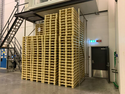 Europaller er plassert i et område av bygget som ikke er dekket av sprinkleranlegg. Dette utgjør både et avvik fra sprinkleranleggets prosjekterte dekningsområde og en feilaktig lagring sett opp mot bruken av arealet og anleggets dimensjonerende kapasitet. Avvik fra god brannsikring.